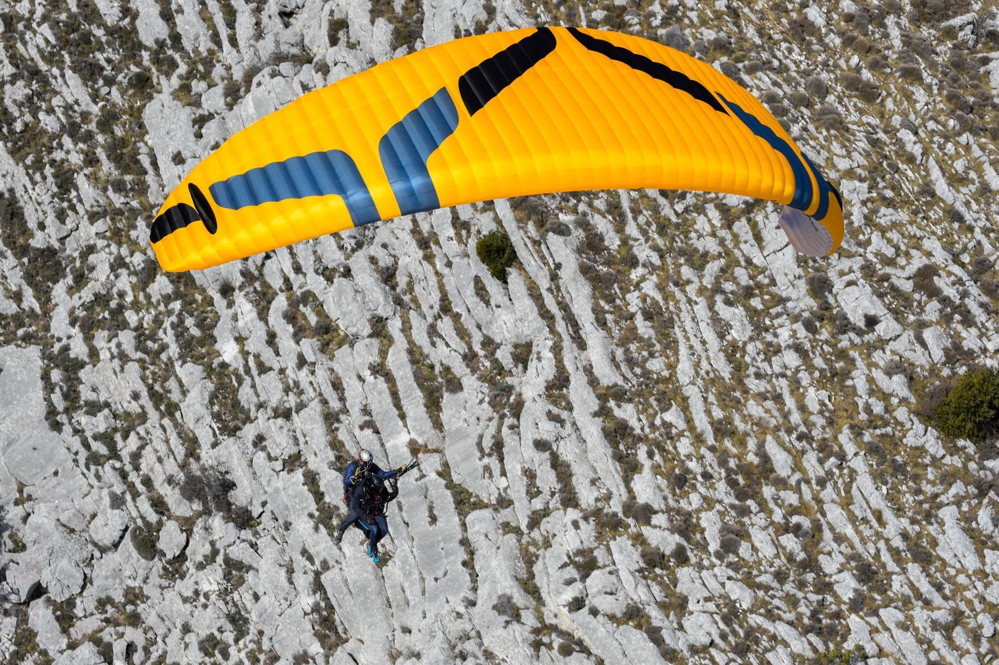Aile de parapente Ozone en vol au-dessus des reliefs des Alpes-Maritimes