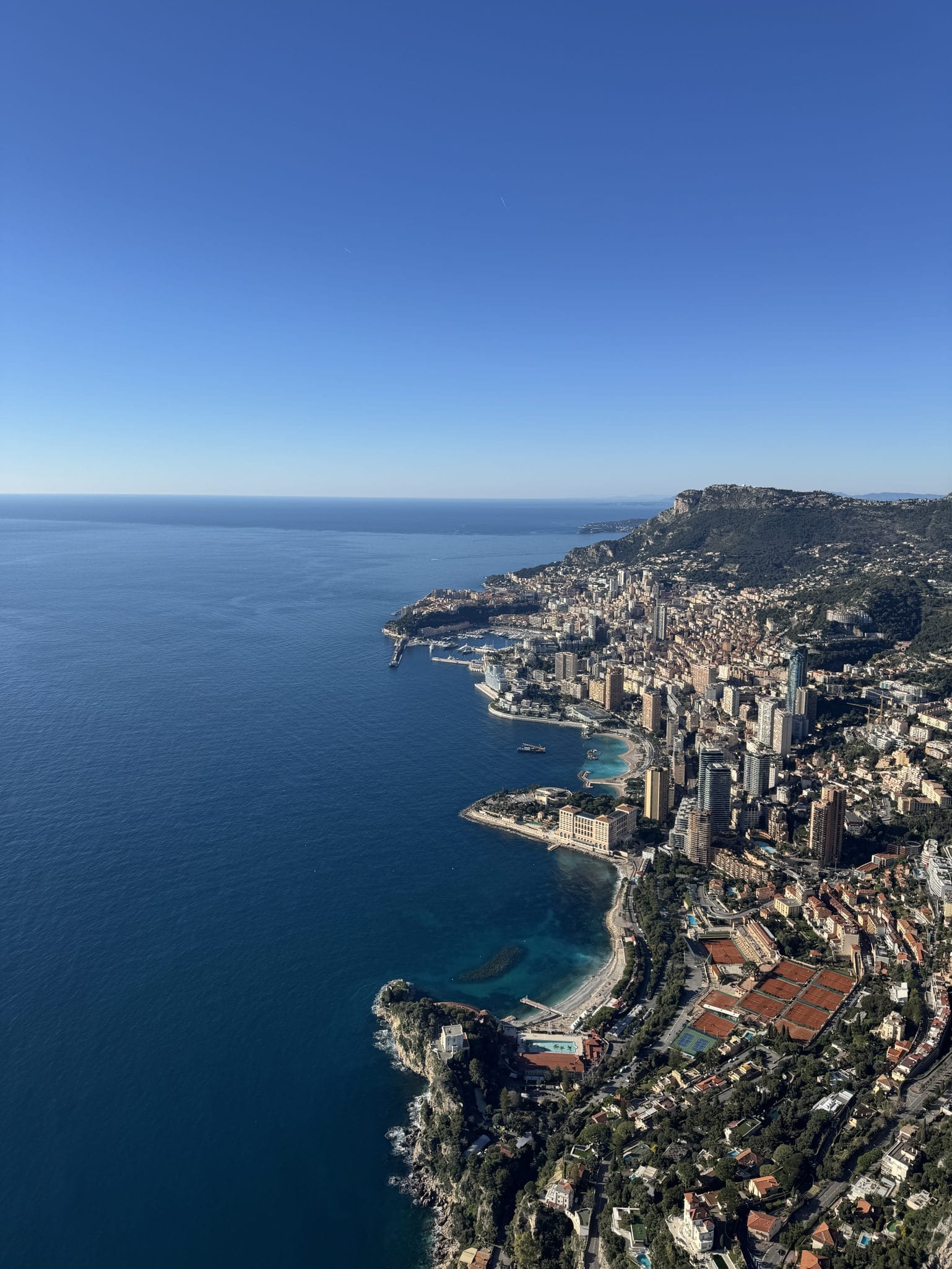 Paragliding flight over the Alpes-Maritimes coast during a cross-country flight, with the sea and coastline below