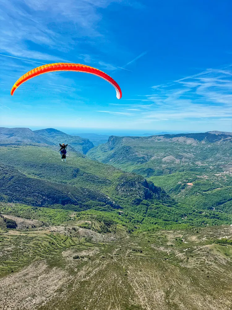 Paragliding flying above the reliefs of Gréolières, a well-maintained sail