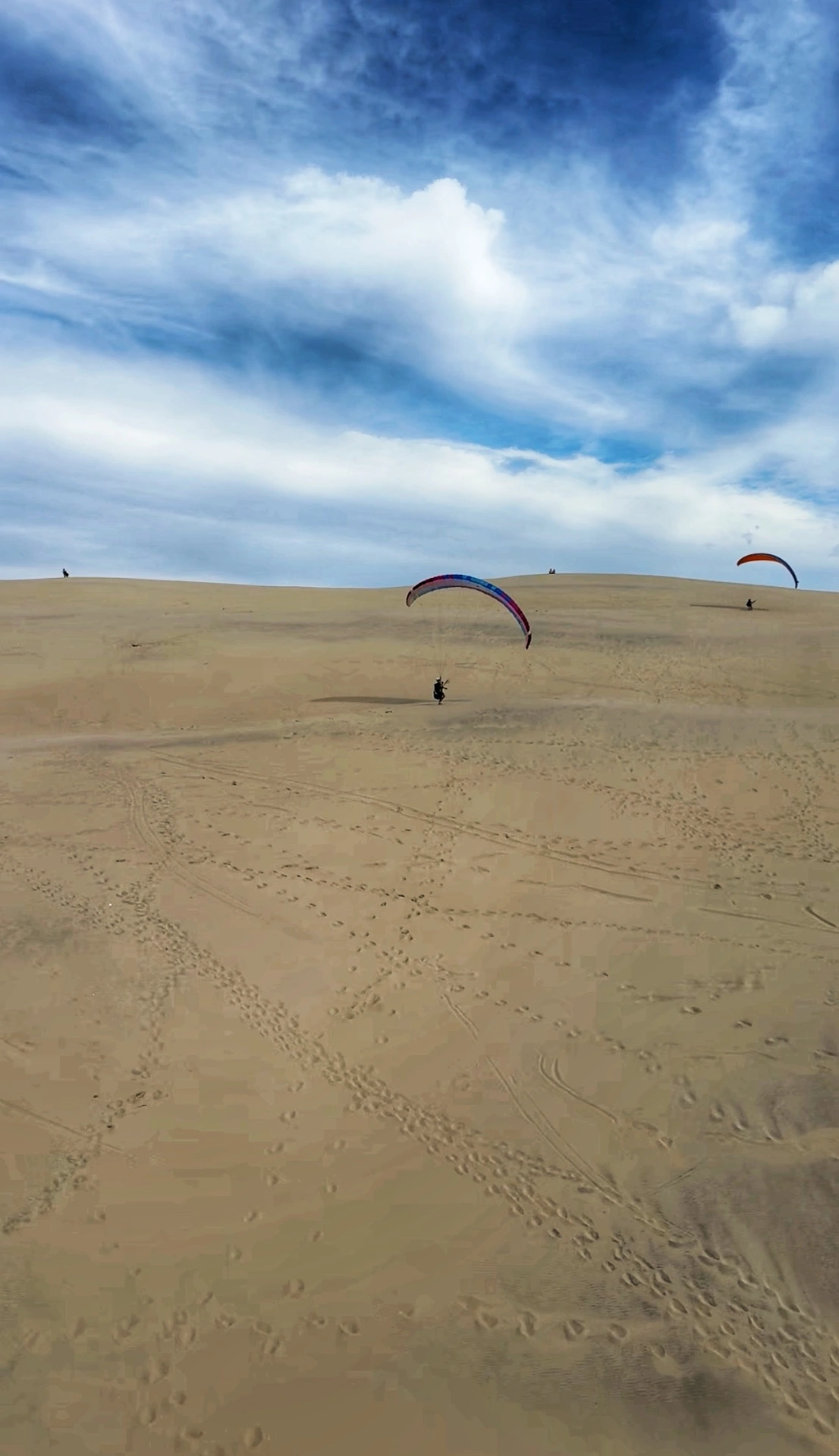 Stage parapente à la Dune du Pyla : pilote sous sa voile sur la pente de sable, avec la Waggas School